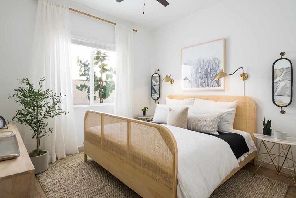 a bedroom with white walls and a bed with a wooden headboard