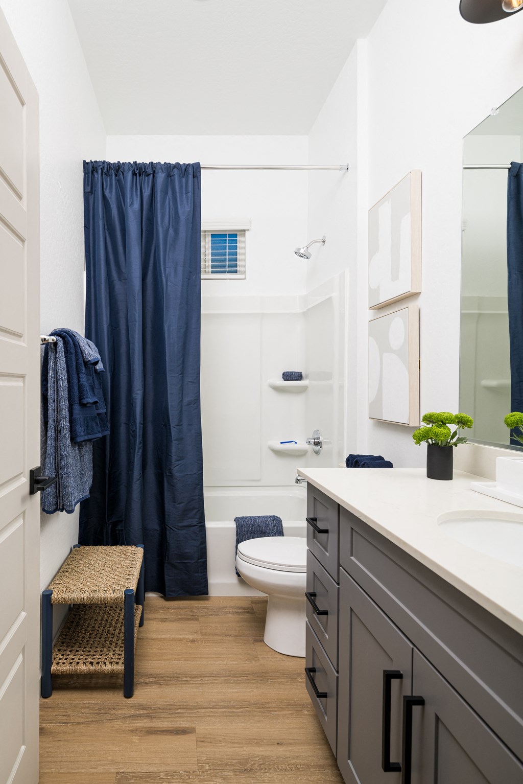 a bathroom with white walls and a blue shower curtain
