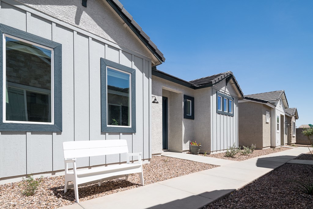 a bench sits in front of a row of houses