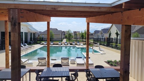 our apartments have a large swimming pool with tables and chairs