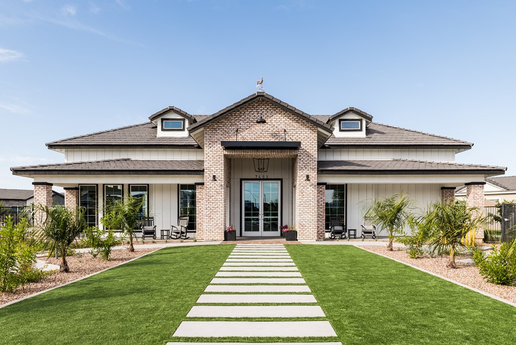 the front of a house with a yard and grass