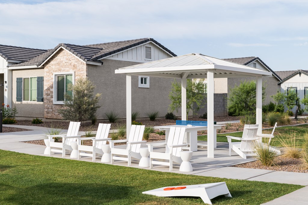 a backyard with a pool and patio with chairs and a canopy