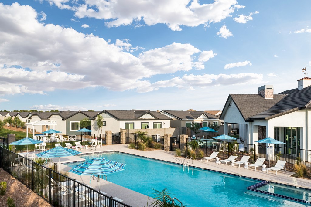 a swimming pool with chairs and umbrellas at the enclave at woodbury apartments