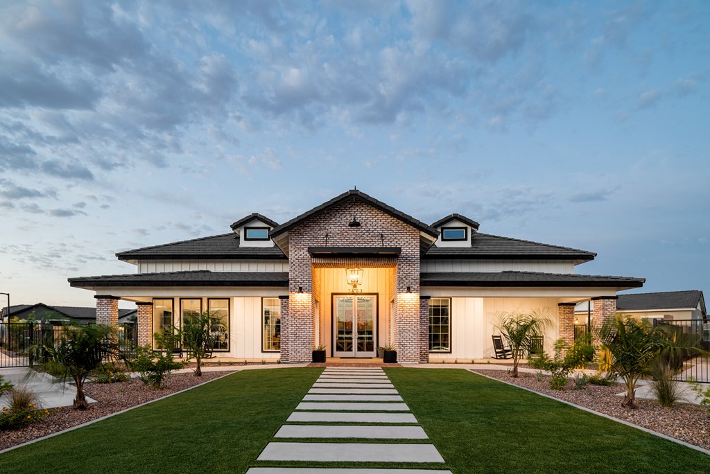 the front facade of a house with a lawn and walkway