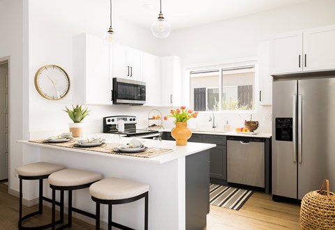 A kitchen with a white counter and a fridge.