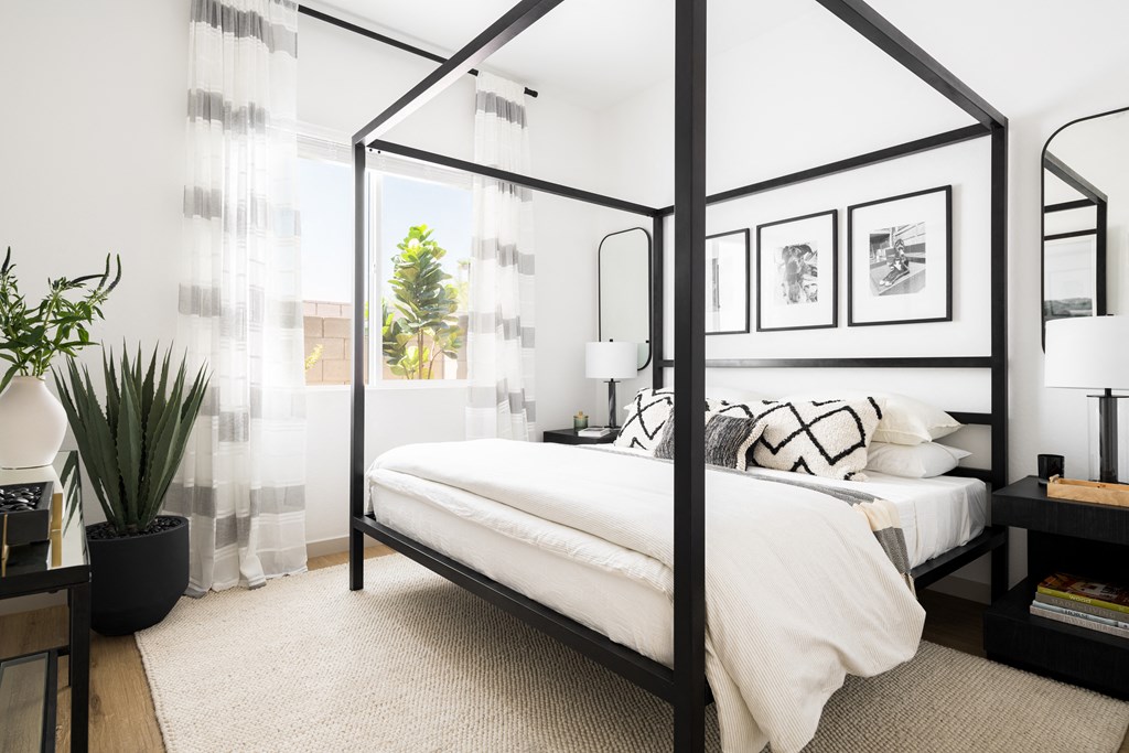 a bedroom with a bed and a black canopy bed