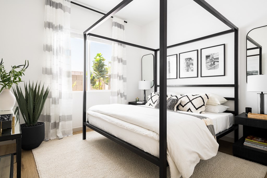 a bedroom with a bed and a black canopy bed