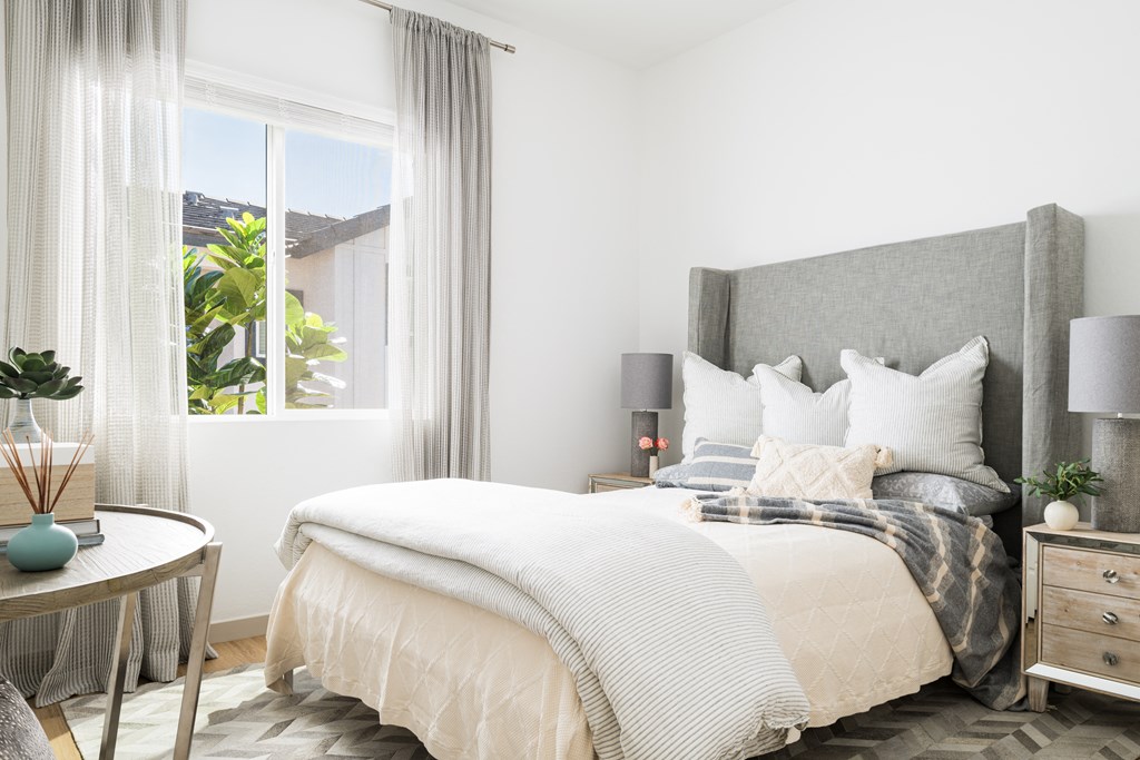 a bedroom with a bed and a large window