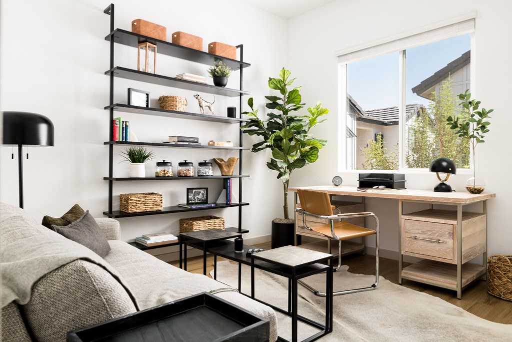 a living room with a couch and a desk and a window
