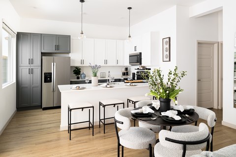 A modern kitchen with a dining table set for four.