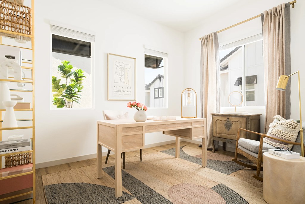 A room with a desk, chair, and a shelf with various items.