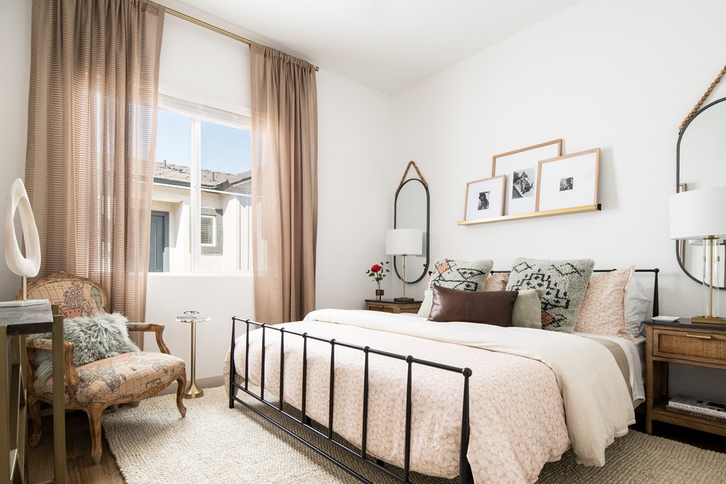 a bedroom with a bed and a chair and a window