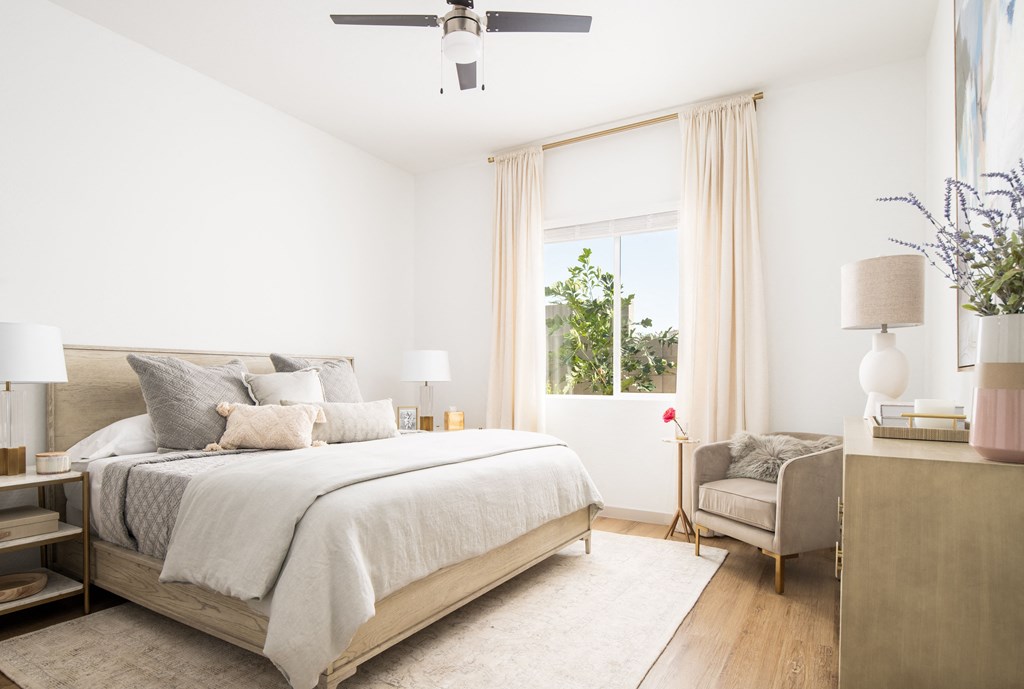 a bedroom with a bed and a chair and a window