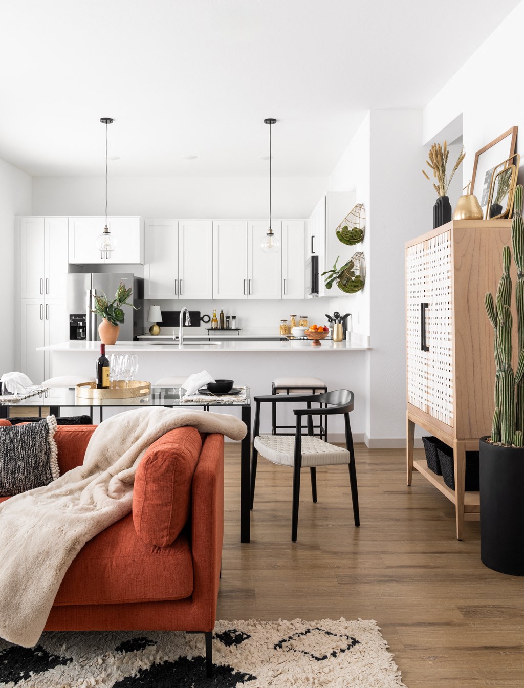 a living room with an orange couch and a kitchen with a table and chairs