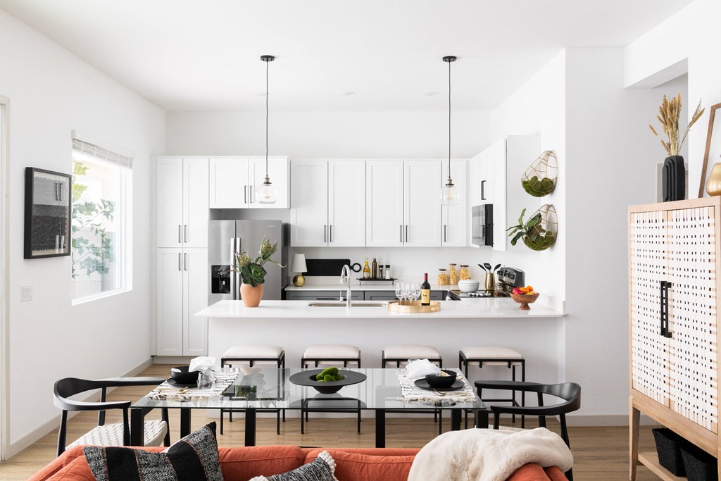a kitchen and living room with a table and chairs