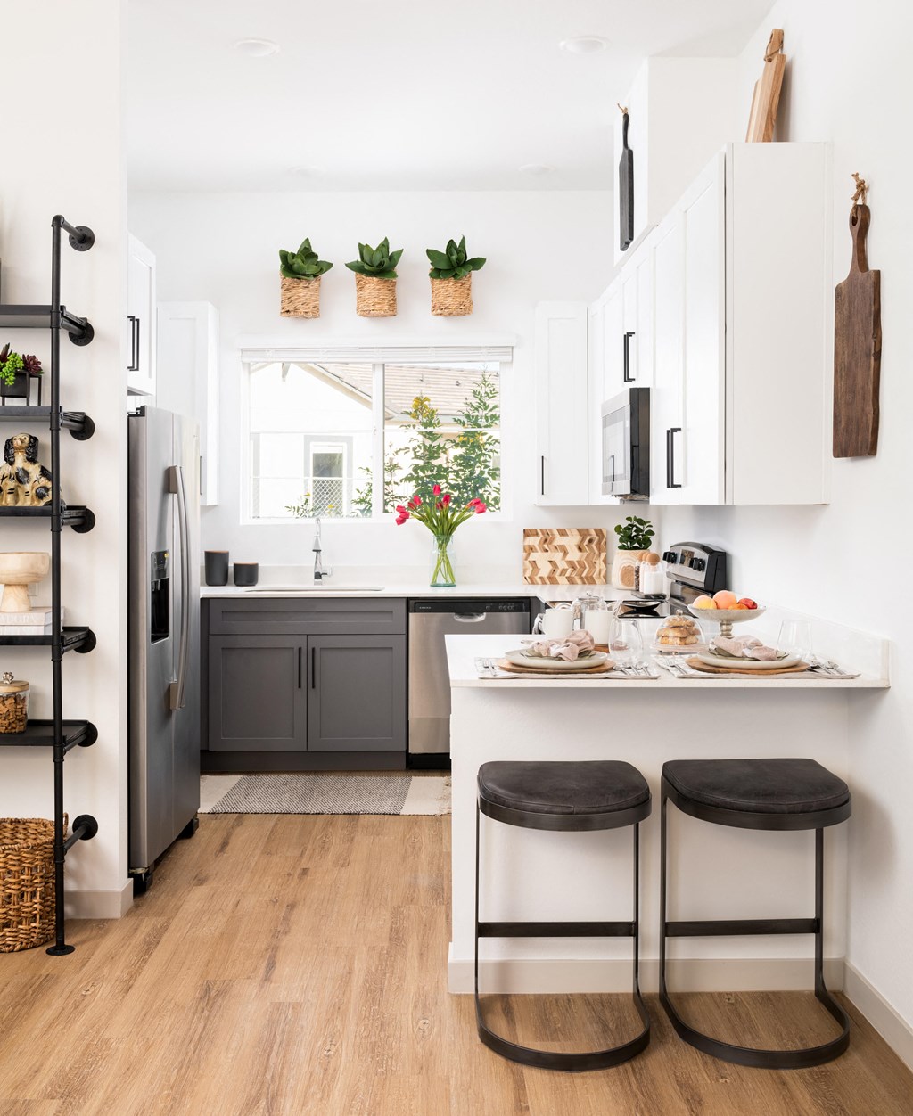 a kitchen with white cabinets and a counter with two stools