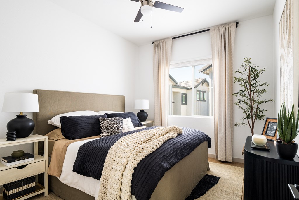 a bedroom with a bed and a ceiling fan