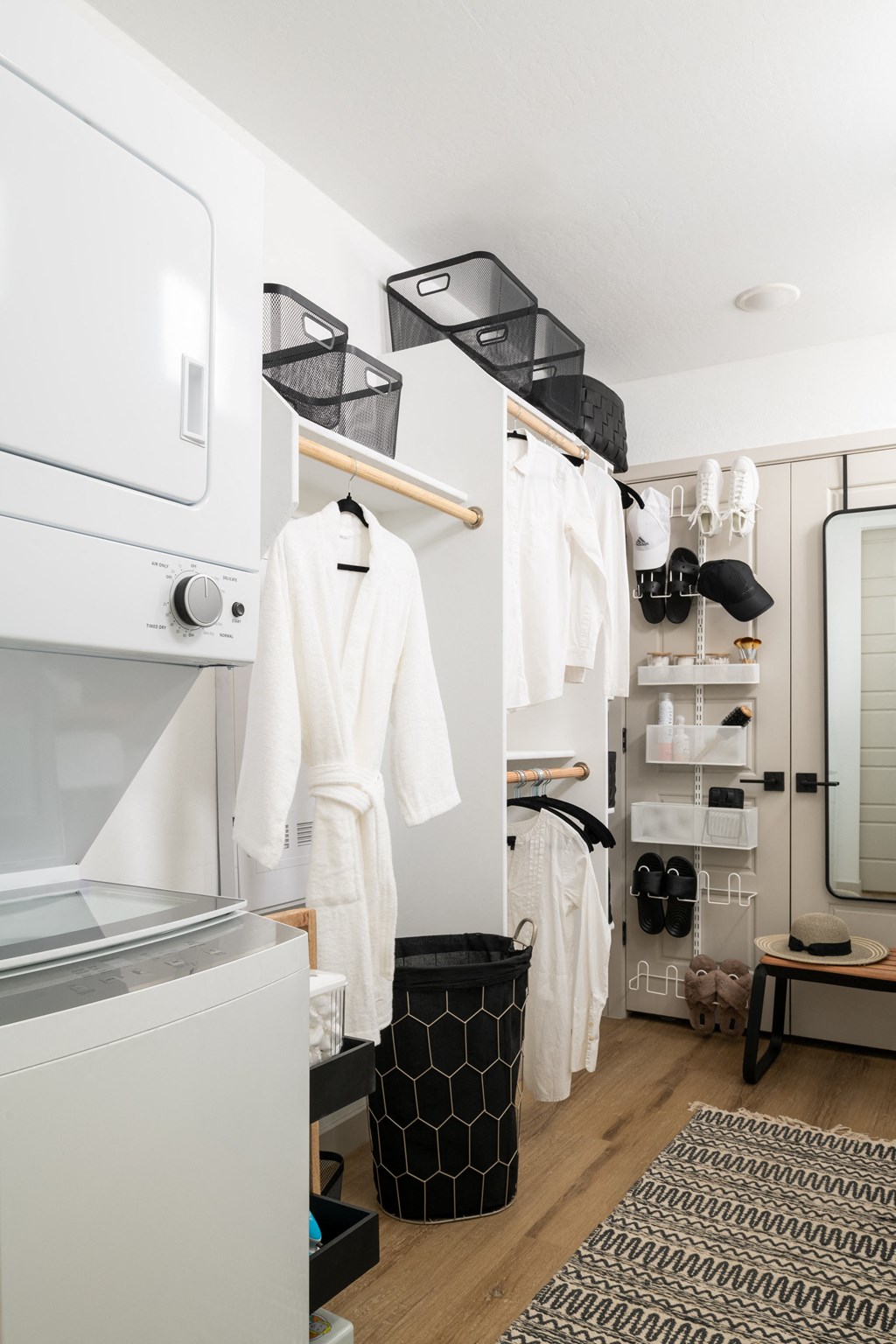 a small bathroom with a white wardrobe and a black and white rug