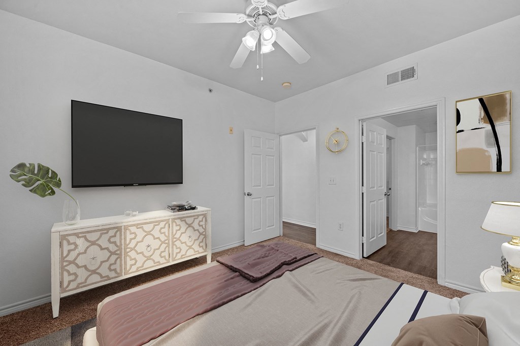 a bedroom with a large bed and a ceiling fan