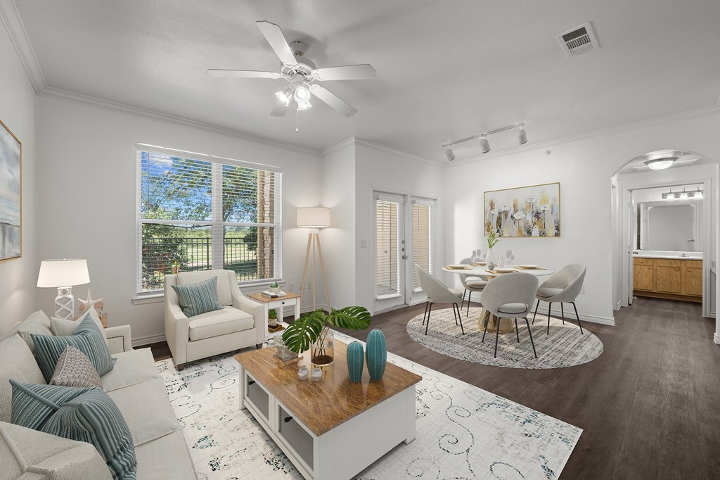 a living room and dining room with white furniture and a ceiling fan