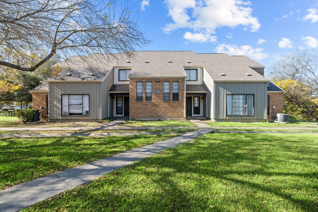 A house with a grey roof and a brick facade.