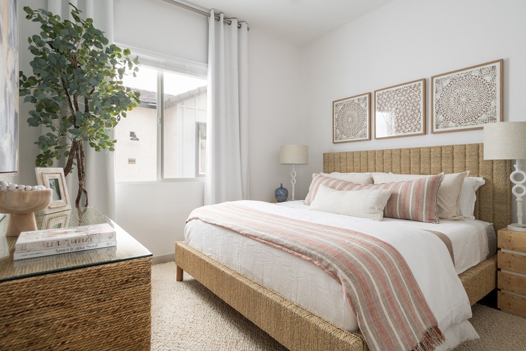 a bedroom with a bed and a table with a plant