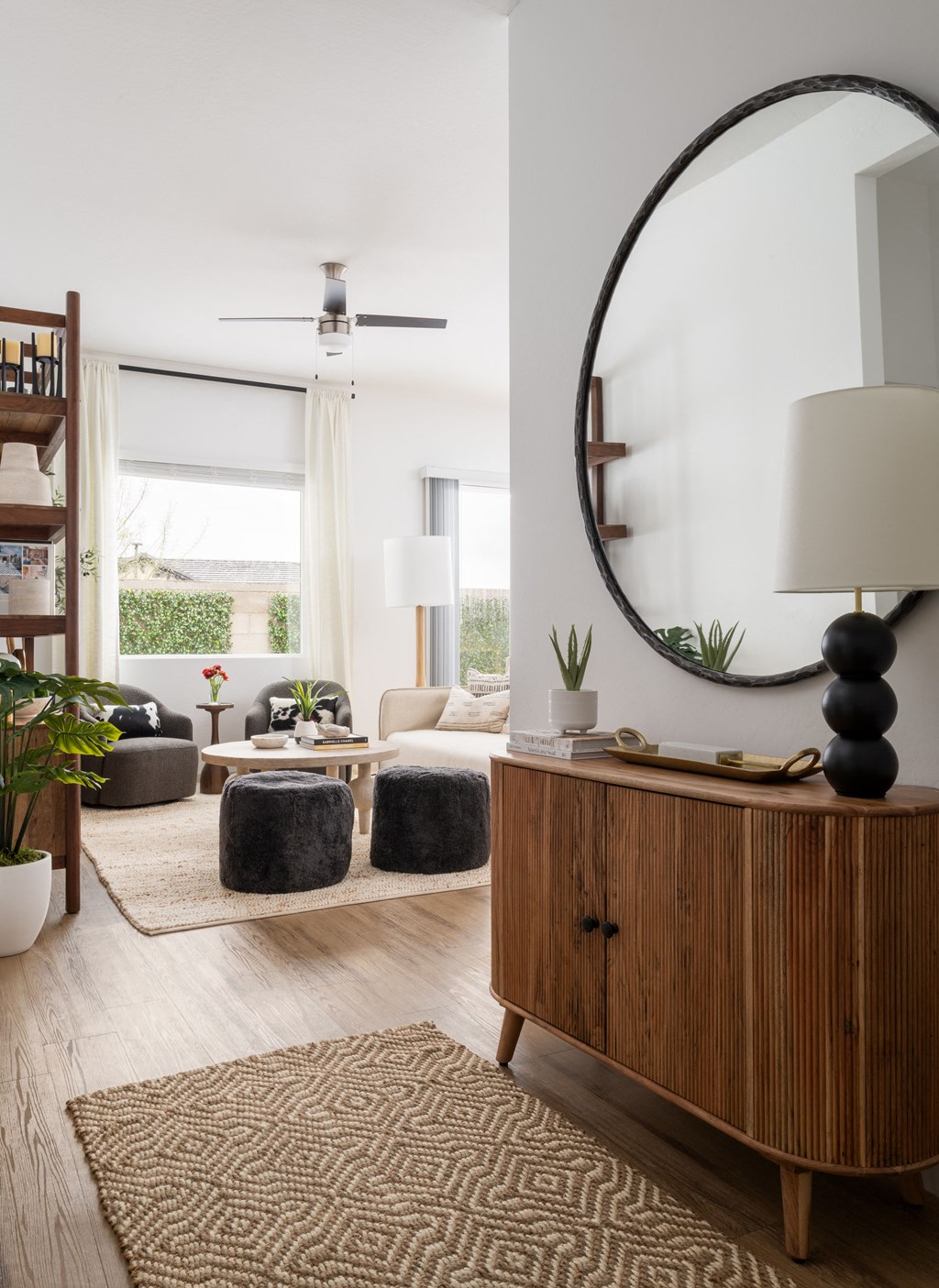 a living room with a large mirror and a wooden dresser