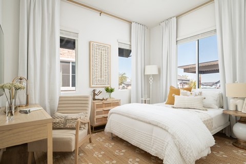 a bedroom with a bed and two windows