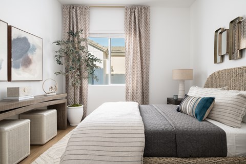 A bedroom with a large bed and a potted plant.