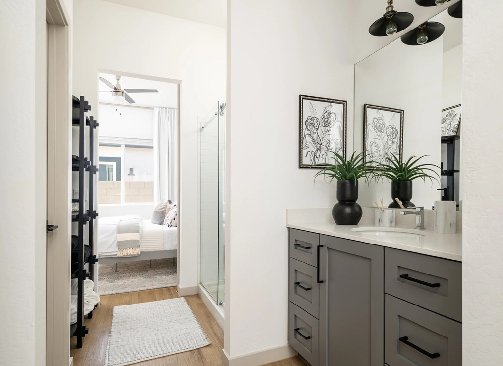 A bathroom with a white countertop and a grey cabinet.