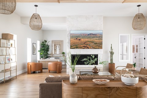 A living room with a large painting of a desert landscape on the wall.