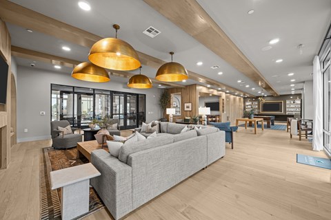 A modern living room with a grey sofa and wooden floors.