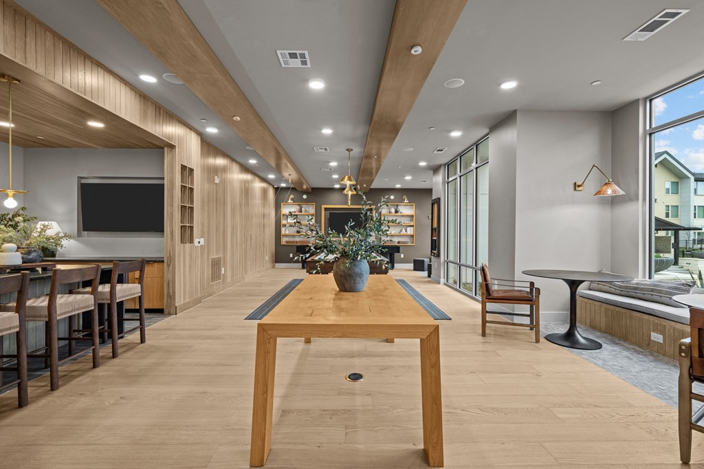 A modern dining room with a long wooden table and chairs.