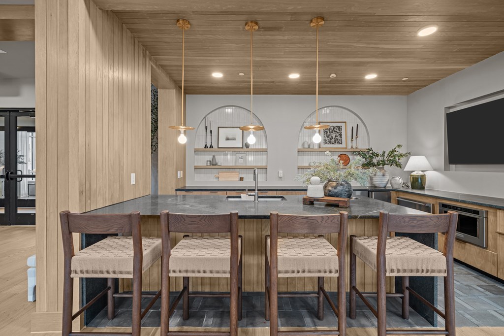 A modern kitchen with a wooden table and chairs.