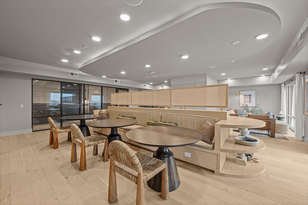 A modern dining room with a large table surrounded by chairs.