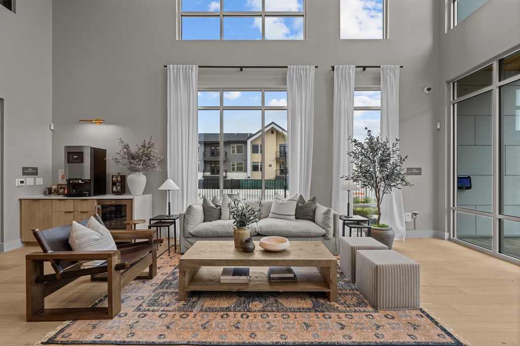 A living room with a large window and a view of a building outside.