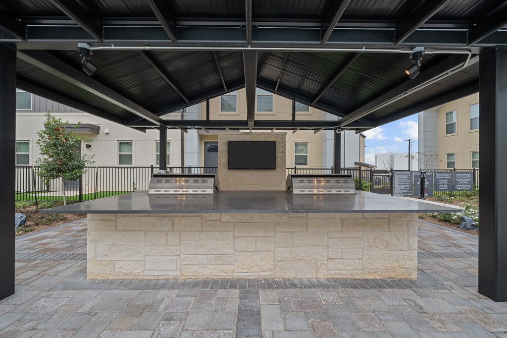 A memorial plaque is mounted on a stone pedestal under a roof.