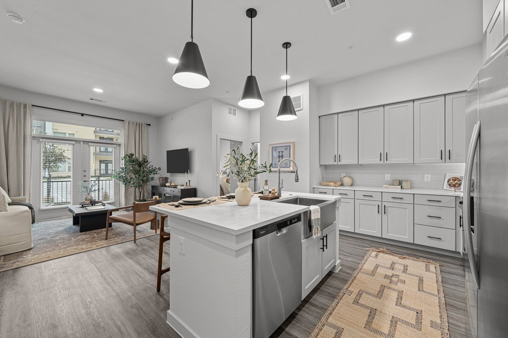 A modern kitchen with a white island and stainless steel appliances.