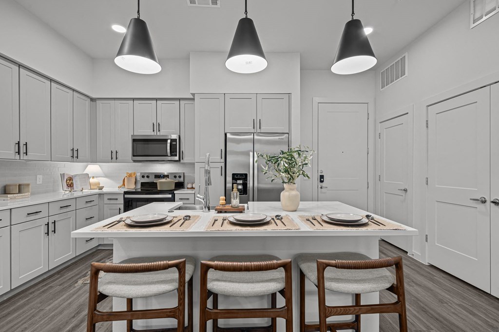 A modern kitchen with a dining table set for two.