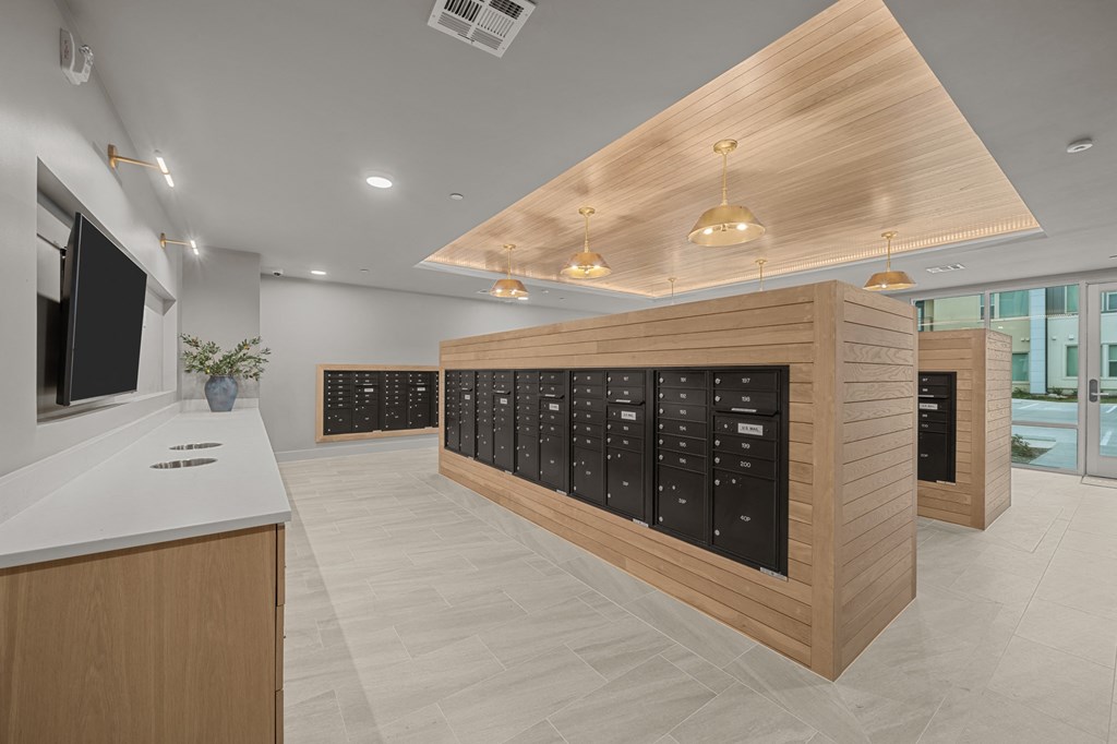 A modern office lobby with a reception desk and a row of lockers.