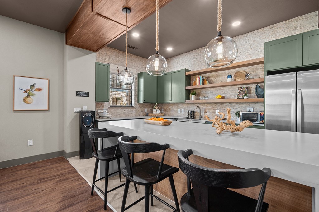 A kitchen with a white countertop and green cabinets.