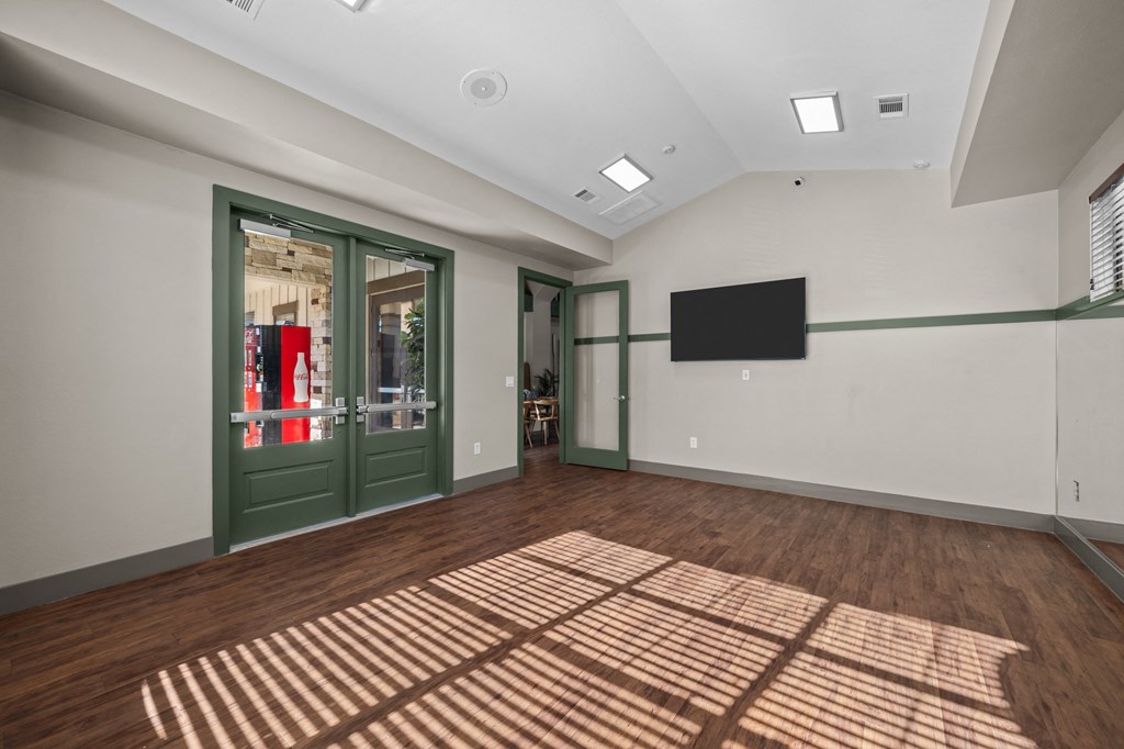 A room with a wooden floor and a green door.