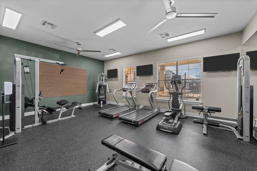 A spacious gym with treadmills, exercise bikes, and other equipment.