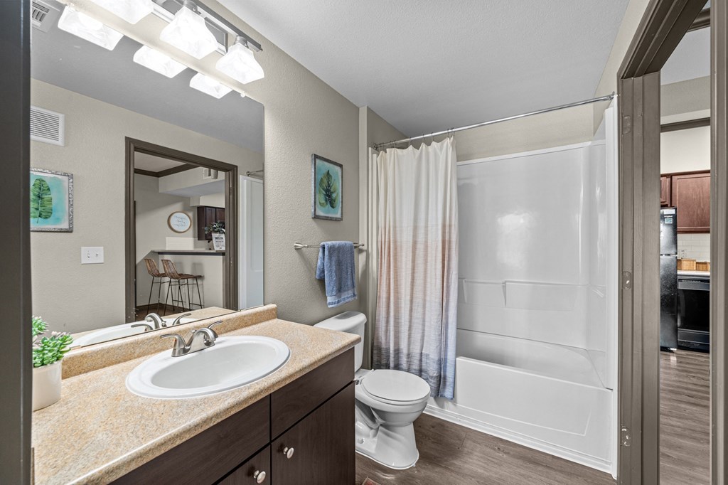 A bathroom with a sink, toilet, and shower.