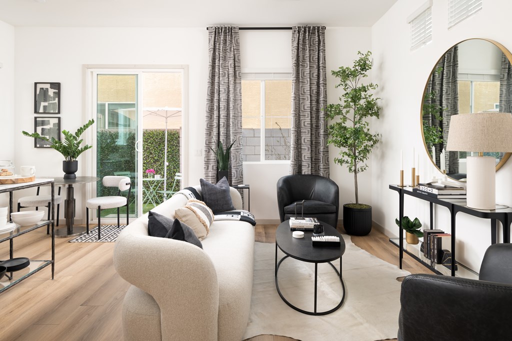 A modern living room with a large grey sofa and a black chair.