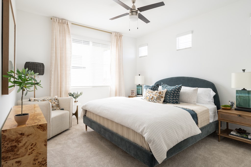 A bedroom with a large bed and a ceiling fan.