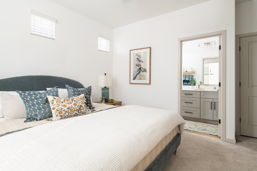 A bedroom with a large bed and a cabinet with a mirror.