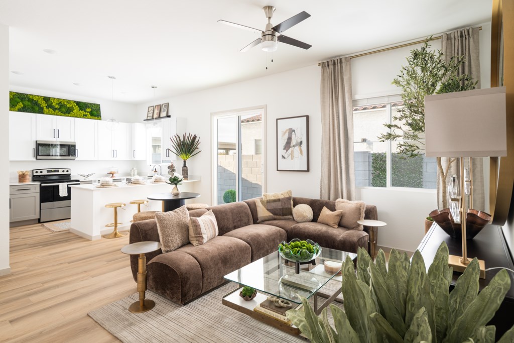 A modern living room with a brown couch and a glass coffee table.
