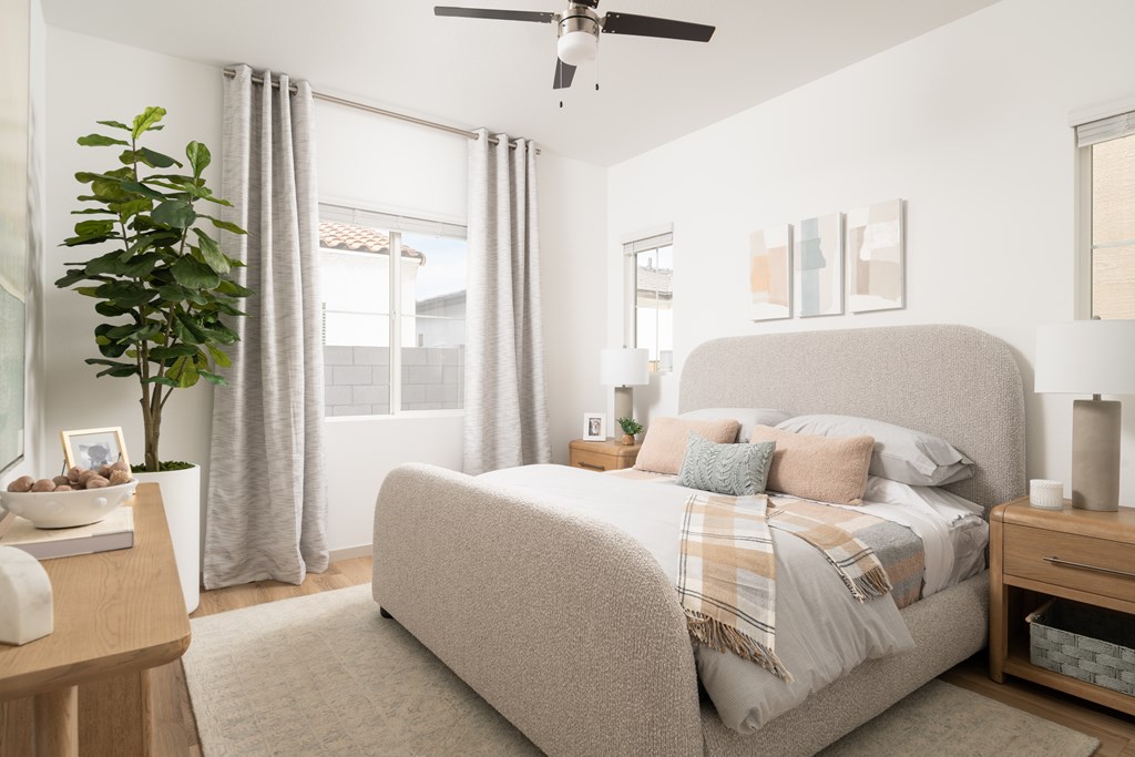 A bedroom with a large bed and a ceiling fan.