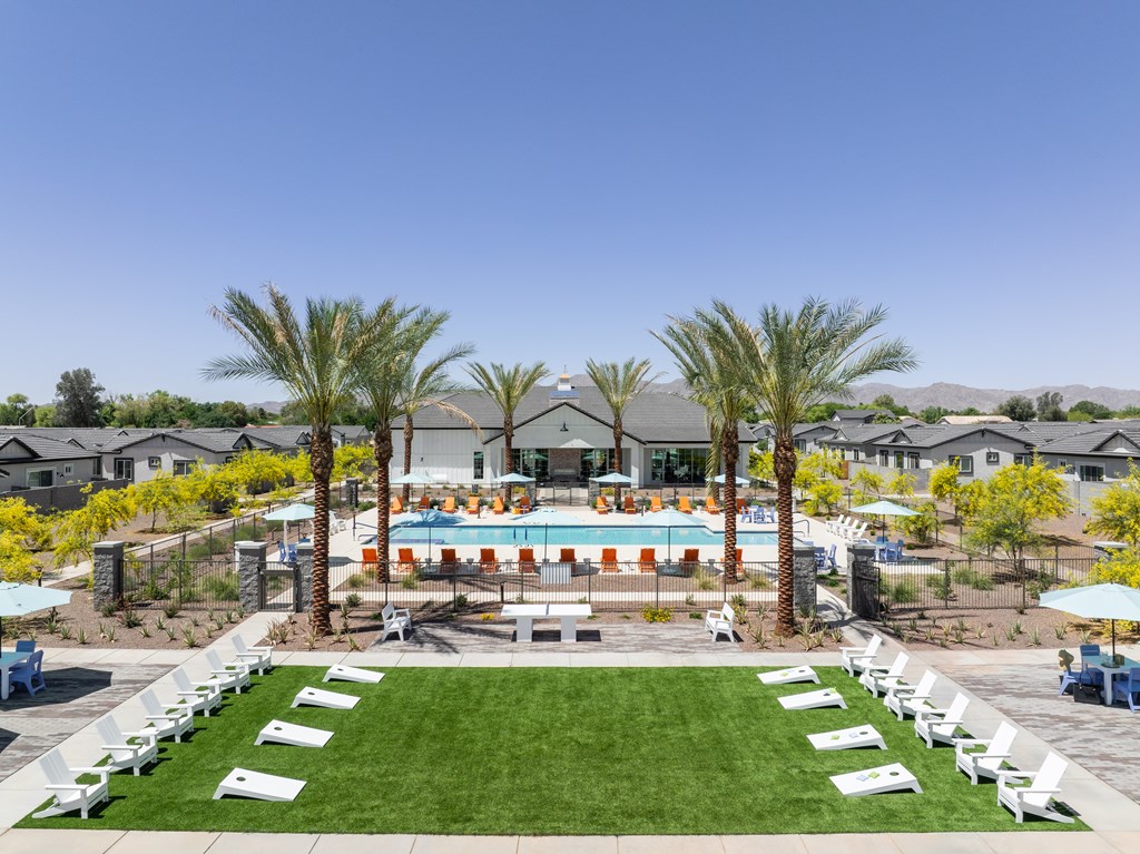 A pool surrounded by palm trees and lounge chairs.